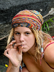 Cute hippie girl with dreadlocks stops for a smoke at the beach. She strips, showing off her full bush and hairy pits.